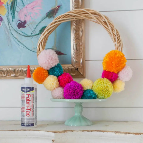 Fast Drying Fabric Glue For Fabrics Canvas Lace Wood And More That Dries Crystal Clear In Minutes And Forms A Permanent Bond Fully Cures In 24 Hours Ideal For Repairs Crafts Hems And Transformations It Works Like A Charm 8 Ounce Bottle Two Pack with colorful pom-poms on a wreath