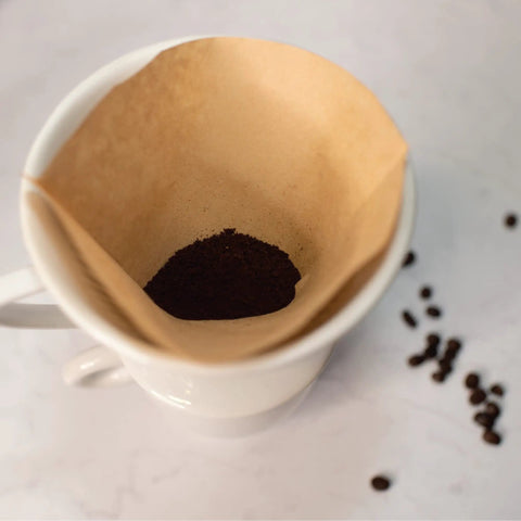 Porcelain Coffee Dripper Size Four, White Ceramic, Manual Pour Over Filter Holder with coffee and filter setup.
