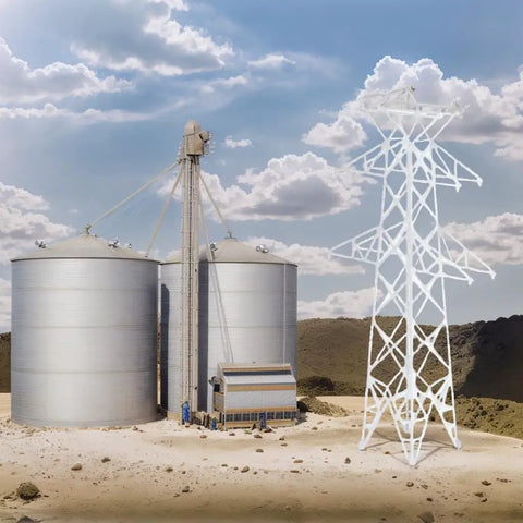 Totally Legit N Scale 1 160 Miniature Electric Transmission Tower beside grain silos in a realistic model railroad scenery.