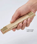 Hand holding Foldable Wood Ruler 6 Ft 6 In With US And Metric Measurements, folded to 9.4 inches, durable wood build