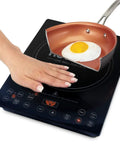 Pro Chef Induction Cooktop Portable 1800W With 8 Inch Heating Coil NSF-Certified showing hand and pan with egg on ceramic surface