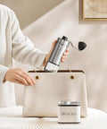 Compact Manual Coffee Grinder With 40 External Grind Settings And Ceramic Conical Burr being placed in a handbag.