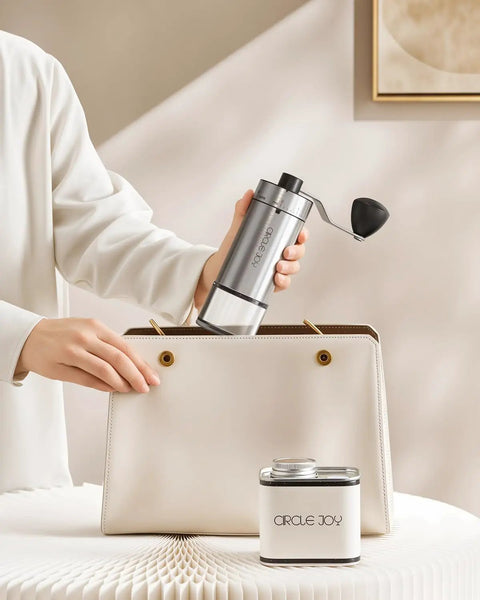 Compact Manual Coffee Grinder With 40 External Grind Settings And Ceramic Conical Burr being placed in a handbag.