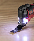 Detailed view of oscillating multi tool from the 20V Brushless Power Tool Combo Kit, illuminated, on wood surface.