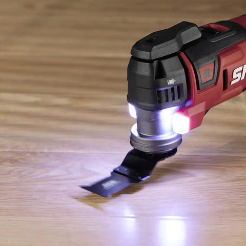 Detailed view of oscillating multi tool from the 20V Brushless Power Tool Combo Kit, illuminated, on wood surface.