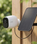 3.2W Solar Panel For Security Cameras Compatible With Arlo Essential XL Waterproof Charger With 13Ft Cable And 360 Degree Adjustable Mount Micro USB And USB C For 5V Rechargeable Cameras mounted on a wooden wall.