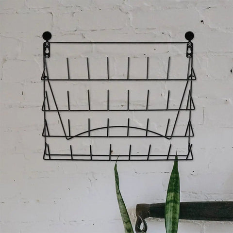 Hella Durable Wall Mount Display Rack Two Pack Iron Hanging Storage Organizer For Mugs Glasses And Home Decor Space Saving Black Rack on a wall.