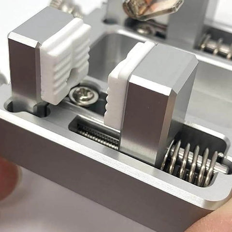 Close-up of adjustable heavy duty soldering jig for circuit board mounting and welding, sturdy aluminum fixture with gears.