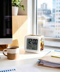 Nifty Little Sunflower Watercolor Floral Bedside Digital Alarm Clock Featuring Sweet Led Nightlight And Easy Snooze Mode For Bedroom Or Home Office Desk Quiet Time Display on white desk with coffee mug.