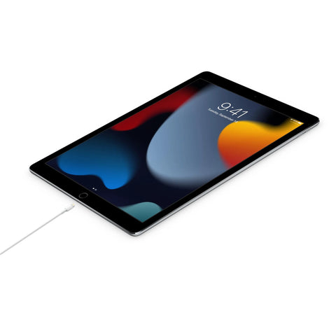 Angled front view of an Apple iPad tablet with a white charging cable attached.