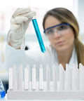 A scientist using a Compact Plastic Test Tube Peg Drying Rack And Laboratory Bench Organizer Straight Up, holding a blue test tube.