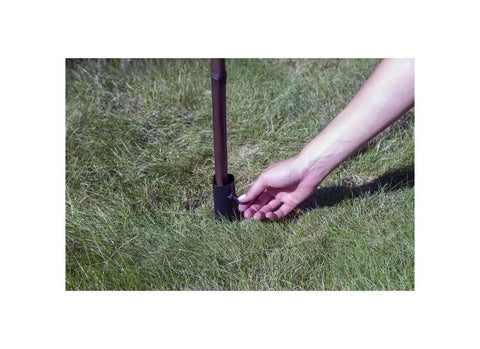 Hand installing Ns Torch Stake For Outdoor Lighting, Heavy Duty Garden Torch Stake With Easy Inground Install into grass for patio paths.