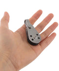 Person holding a stainless steel cable pulley block, part of a set of 4 with bearings, designed for kayak and marine gear use.