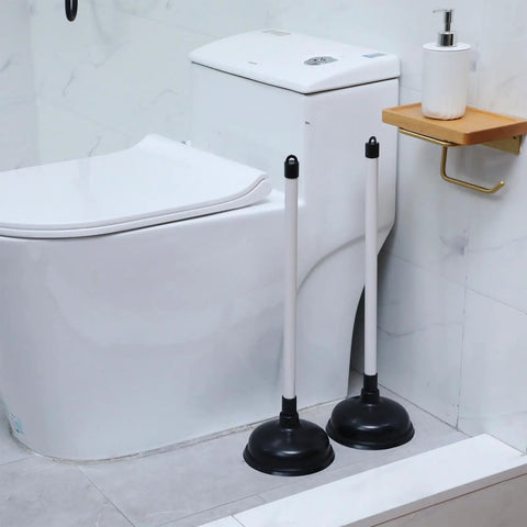 Top Shelf Heavy Duty 12 Pack Toilet Plungers Total Game Changer For Any Household With Rock Solid Extra Long Grip Handle And Insane Suction Power To Straight Up Crush Stubborn Bathroom Clogs Fast In Black, two plungers beside a toilet.
