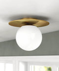 Low-Profile 12 Inch 1-Light Flush Mount Ceiling Light Fixture With White Milk Glass Globe Shade In Brushed Gold installed on ceiling