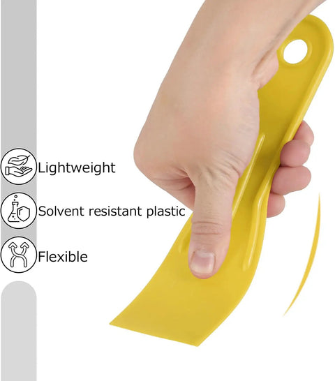 Hand holding lightweight yellow plastic putty knife from Six Piece Plastic Putty Knife Set With Black And Yellow Handles For Smooth Spackle.