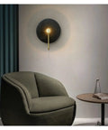 Retro Round Wall Sconces Crafted From Premium Copper With Rust Proof Build And Glare Free Warm Glow To Level Up Your Bedroom Bedside Or Living Room Setup Today 32 Cm Fixture mounted beside a green chair.