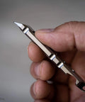 Hand holding Titanium Ti Pry Mini Pry Bar Keychain EDC Pocket Pry Tool With Bottle Opener, built from 6Al4V titanium.