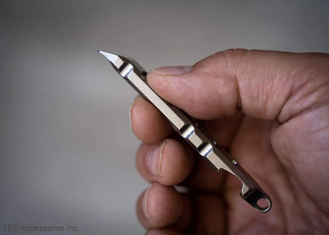 Hand holding Titanium Ti Pry Mini Pry Bar Keychain EDC Pocket Pry Tool With Bottle Opener, built from 6Al4V titanium.