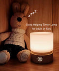 Dimmable LED Night Light With Timer For Nursery And Kids Bedroom, Woodgrain Bedside Lamp beside stuffed animal