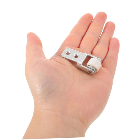 Heavy Duty Nylon Sliding Door Rollers With Smooth As Butter Ride For Cabinets And Drawer Units Features Six One Inch White Pulleys in hand for size reference.