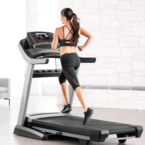 Women running on treadmill, using Universal Round Key Replacement, keeping fit with the Red Magnetic Treadmill Safety Key in home gym