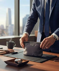 Businessman holding an On The Go Dopp Kit Toiletry Bag For Men Water Repellent Nylon Travel Pouch in an office setting