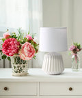 Petite Pleated Ceramic Table Lamp With Off White Fabric Shade 5 Ft Cord 40W Equivalent Type B Bulb Not Included Classic English Style Accent Light For Bedroom Or Living Room Cozy Glow beside flowers on white table