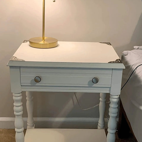 Two Point Five Inch Four Piece Antique Brass Corner Brackets For Furniture Edge Guarding And Vintage Home Decor Makeover featuring elegant brass corner brackets on a wooden nightstand.