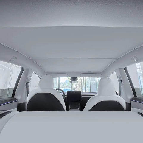 Interior view of Tesla Model Y with full blackout roof sunshade installed, featuring dual layer fabric and graphene UV coating for no light leaks.