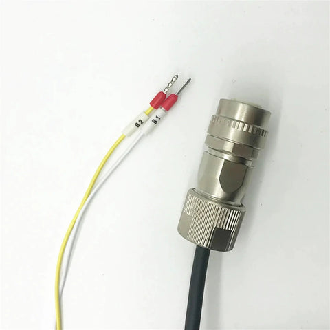 Close-up of a metal circular connector with knurled lock and black cable; yellow and white wires with red caps labeled B1/B2.