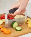 HIC Kitchen crinkle-cut wave slicer with stainless steel blade and black handle on a cutting board.