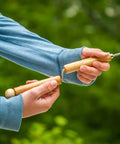 Person holding Marshmallow Roasting Sticks Set Of 2 With Multiple Attachments for campfire cooking, showing easy spin handle.