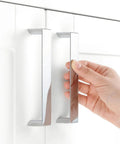 10 Pack 5 Inch Polished Chrome Cabinet Pulls being installed on a white kitchen cabinet door with 128mm hole centers