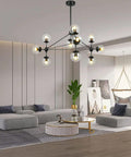 10 Light Modern Black Sputnik Chandelier With Clear Globe Shades in a stylish living room with grey sofas and a hammock chair.