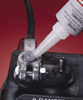 Applying dielectric tune-up grease for electrical connections to a battery terminal, creating a moisture-proof barrier against corrosion.