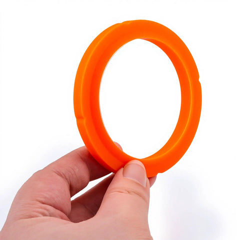 Hand holding Conical Group Head Gasket Seal For La Marzocco Espresso Machines, orange, food-grade, BPA-free.