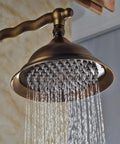 UMJIGF 8 Inch Antique Shower System with Hot and Cold Water Shower Combo Set Multifunction Single Handle Shower Faucet Set with Top Fall Shower Head pouring water from a brass shower head.