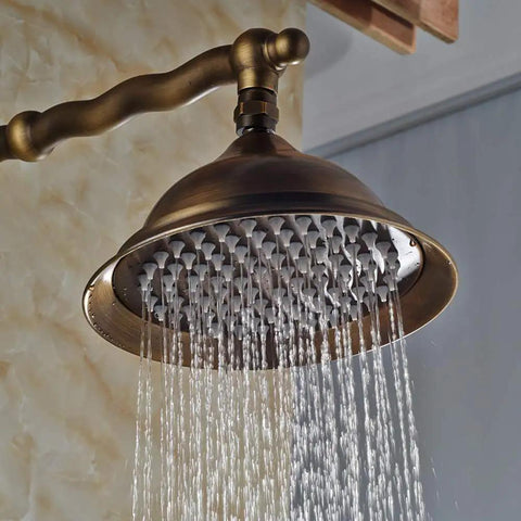UMJIGF 8 Inch Antique Shower System with Hot and Cold Water Shower Combo Set Multifunction Single Handle Shower Faucet Set with Top Fall Shower Head pouring water from a brass shower head.
