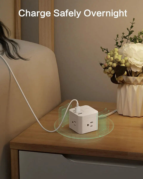 Ultra Compact Six Outlet Surge Protector With Three AC Outlets And Three USB Ports on a nightstand, charging devices.