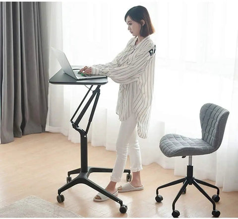 Zero Stress Height Adjustable Standing Desk With Smooth Roll Mobile Laptop Cart And Weight Bearing Pneumatic Lift For Relaxed Home Office Flex Setup White, in use with a woman standing.