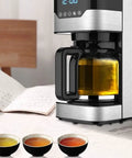 Modern four cup coffee maker with timer, pause and pour, anti-drip brew, stainless steel carafe on a kitchen counter.