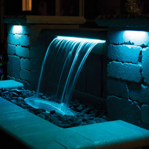 Outdoor waterfall illuminated by LED Color Changing Hardscape Light 6-Inch Multicolored With Oil Rubbed Bronze Finish.