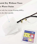 Lens cleaning wipes package and black-framed glasses on white surface