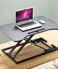 Portable Sit Stand Desk Converter With Heavy Duty Dual Tray Ergonomic Stand on wooden surface with laptop and mouse.