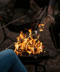 People roasting marshmallows over a 22 Inch Outdoor Wood Burning Fire Pit With Mesh Lid And Fire Picker Durable Alloy Steel Pit.