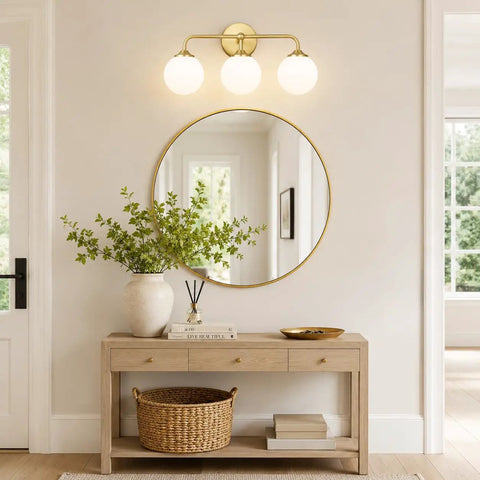 Dope Mid Century 3 Light Vanity Fixture With Smooth Brushed Gold Finish And Soft Milky White Glass Ball Shades above a mirror.