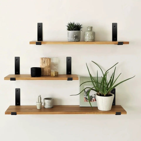 Matte Black J Lip Wall Shelf Brackets Hella Sturdy 8 Pack supporting wooden shelves with plants and decor on a wall.