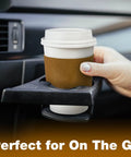 Hand placing Leak-Proof 12 Oz Coffee Cup with Lid and Sleeve into car holder, perfect for travel, spill-free.