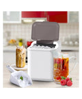 Fast Countertop Ice Maker Portable With Self Cleaning Setup Produces Crisp Cubes In Minutes And Delivers Twenty Six Point Five Pounds Daily is in a kitchen with ice scoop.